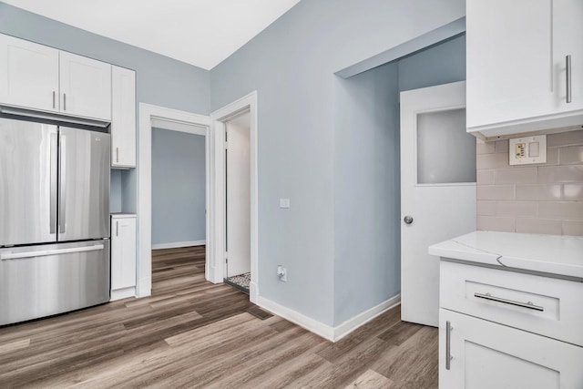 13916 S Dearborn St, Riverdale, IL 60827 - kitchen with light wood-style flooring, freestanding refrigerator, baseboards, backsplash, and white cabinetry