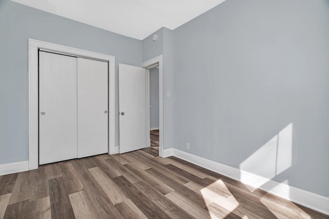 13916 S Dearborn St, Riverdale, IL 60827 - unfurnished bedroom with baseboards, wood finished floors, and a closet