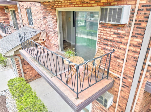 exterior space with brick siding, outdoor dining space, visible vents, and a balcony