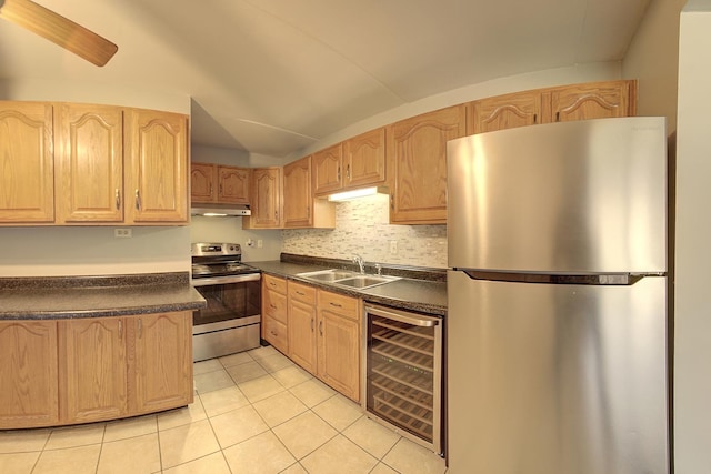 kitchen with under cabinet range hood, wine cooler, dark countertops, a sink, and appliances with stainless steel finishes