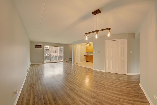 unfurnished living room with baseboards and light wood-type flooring