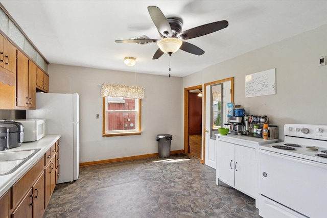 204 S Jackson Ave, Polo, IL 61064 - kitchen featuring stone finish flooring, ceiling fan, light countertops, baseboards, and white appliances