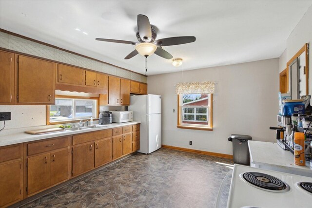 204 S Jackson Ave, Polo, IL 61064 - kitchen with light countertops, a healthy amount of sunlight, stone finish floor, and white appliances