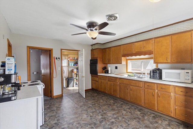 204 S Jackson Ave, Polo, IL 61064 - kitchen featuring brown cabinets, white microwave, stone finish floor, light countertops, and black oven