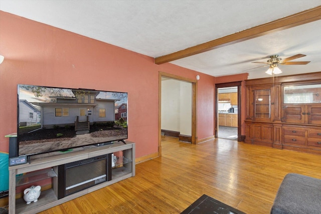 204 S Jackson Ave, Polo, IL 61064 - living room featuring beamed ceiling, a ceiling fan, wood finished floors, and baseboards