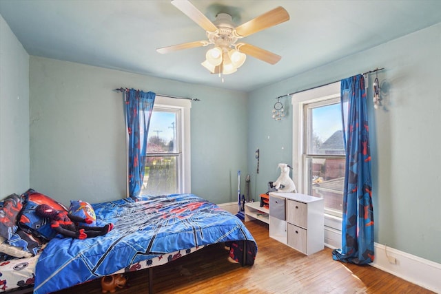 204 S Jackson Ave, Polo, IL 61064 - bedroom featuring a ceiling fan, multiple windows, wood finished floors, and baseboards