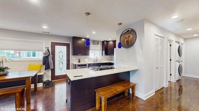 5743 Sherman Ave, Downers Grove, IL 60516 - kitchen with light countertops, stacked washer / drying machine, a sink, and dark wood-type flooring