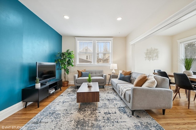 living area with baseboards, wood finished floors, and recessed lighting
