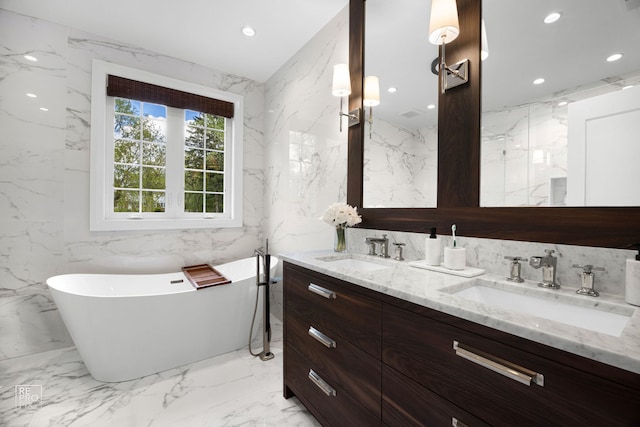 301 Canterbury Ln, Inverness, IL 60010 - bathroom with stone wall, marble tiled floors, a freestanding tub, double vanity, and recessed lighting