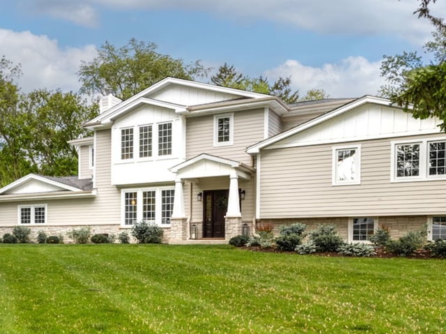 301 Canterbury Ln, Inverness, IL 60010 - view of front facade featuring board and batten siding, a front yard, and a chimney