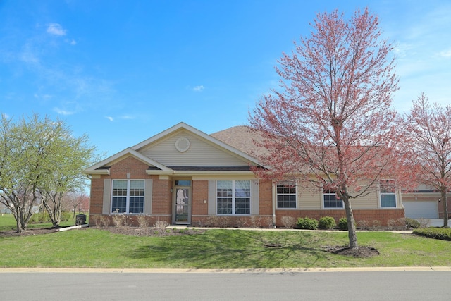 single story home featuring brick siding and a front yard