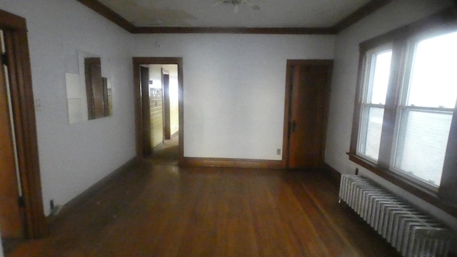 interior space featuring baseboards, crown molding, wood finished floors, and visible vents