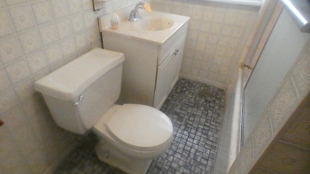 bathroom featuring tile walls, tile patterned floors, vanity, and toilet