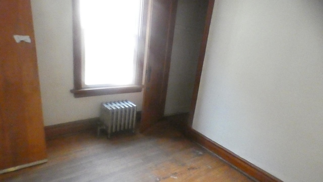 empty room featuring radiator and light wood-type flooring