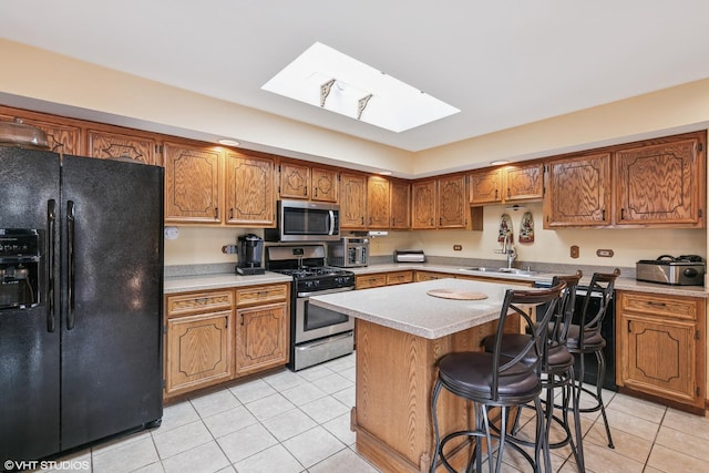 91 Frances Ln, Chicago Heights, IL 60411 - kitchen featuring light tile patterned floors, a skylight, appliances with stainless steel finishes, and a sink