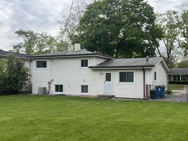 rear view of property featuring cooling unit and a chimney