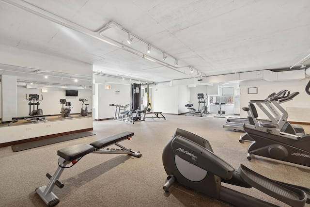 workout area featuring track lighting and baseboards