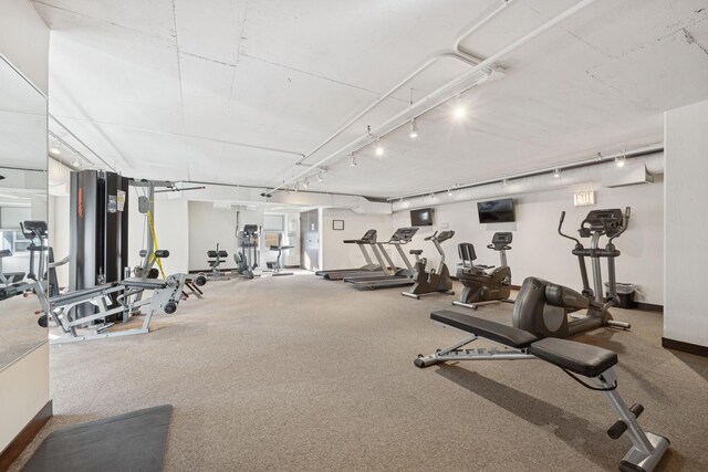 workout area featuring carpet floors, baseboards, and track lighting
