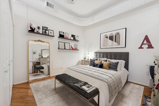 bedroom featuring visible vents, baseboards, and wood finished floors
