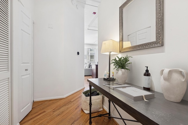 office space with a heating unit, baseboards, and light wood-type flooring