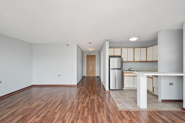 1122 N Clark St Unit 1702, Chicago, IL 60610 - kitchen with freestanding refrigerator, light countertops, a sink, wood finished floors, and a textured ceiling