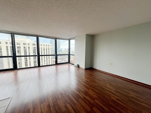 1122 N Clark St Unit 1702, Chicago, IL 60610 - unfurnished room with wood finished floors, a textured ceiling, a city view, baseboards, and a wall of windows