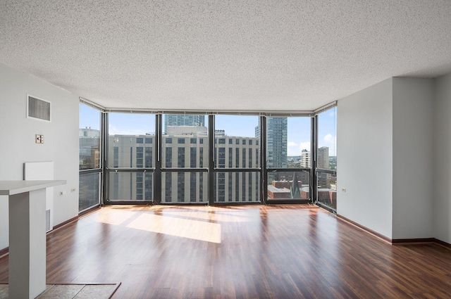 1122 N Clark St Unit 1702, Chicago, IL 60610 - empty room with a textured ceiling, wood finished floors, a city view, floor to ceiling windows, and baseboards