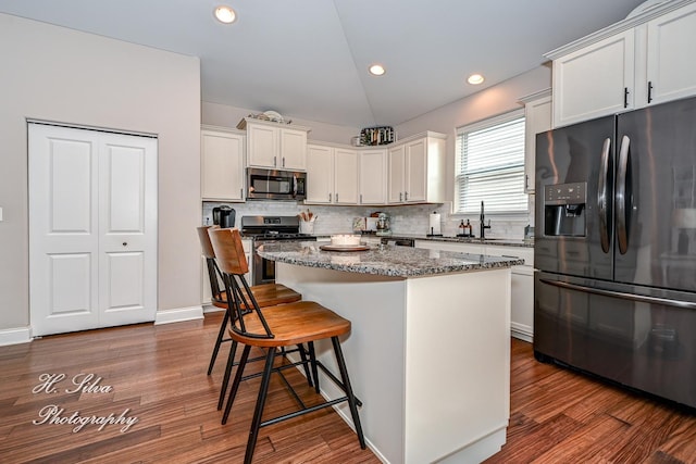 730 Goodfield Lndg, Elgin, IL 60124 - kitchen with a kitchen island, backsplash, a kitchen bar, white cabinets, and stainless steel appliances