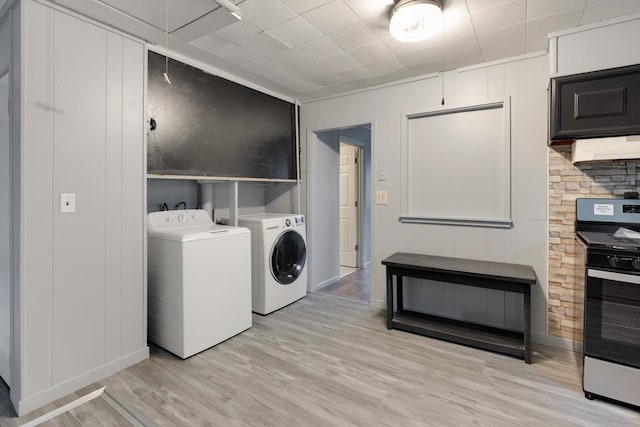 washroom featuring washer and clothes dryer, attic access, light wood-style flooring, and baseboards