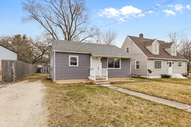 view of front of home with dirt driveway, a shingled roof, a shed, and a chimney