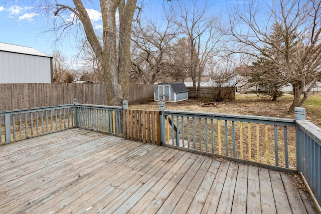 wooden terrace with a storage shed, a fenced backyard, and an outdoor structure