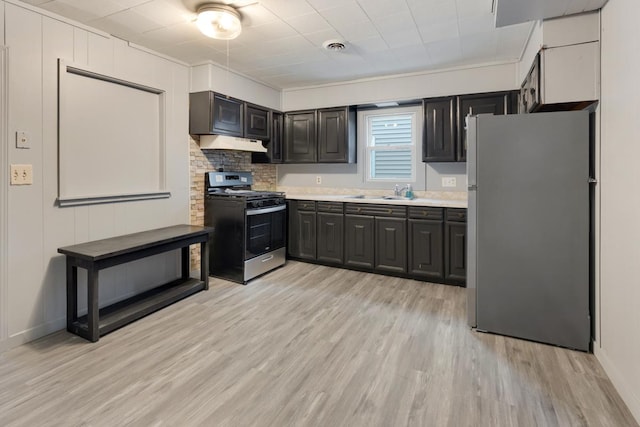 kitchen featuring appliances with stainless steel finishes, light countertops, under cabinet range hood, and light wood-type flooring