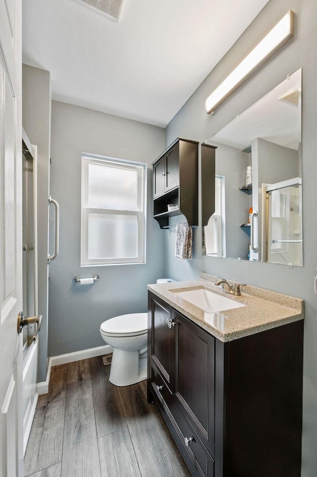 6522 S Kostner Ave, Chicago, IL 60629 - full bath featuring wood finished floors, vanity, a shower with door, toilet, and visible vents