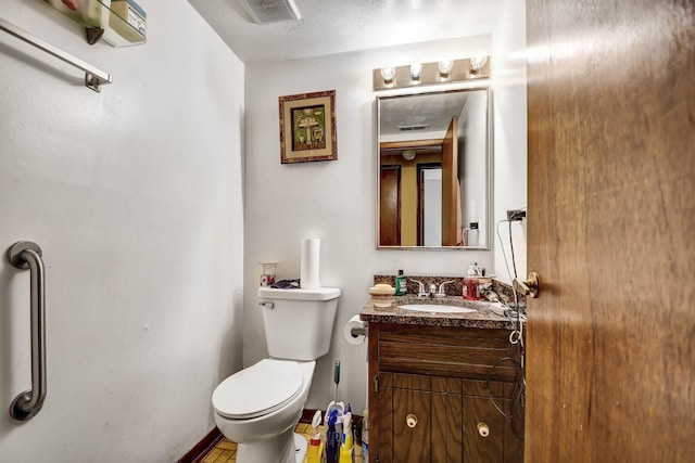 half bathroom with vanity, toilet, and visible vents