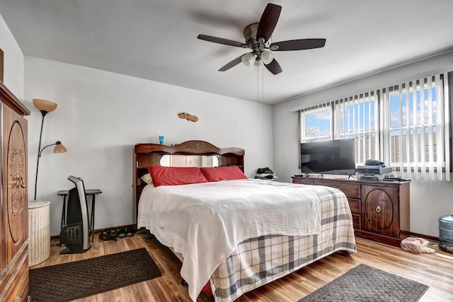 bedroom with baseboards, ceiling fan, and wood finished floors