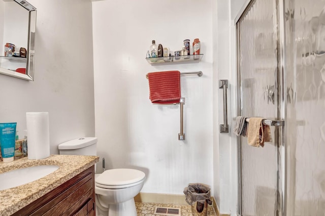 bathroom with visible vents, a stall shower, vanity, baseboards, and toilet