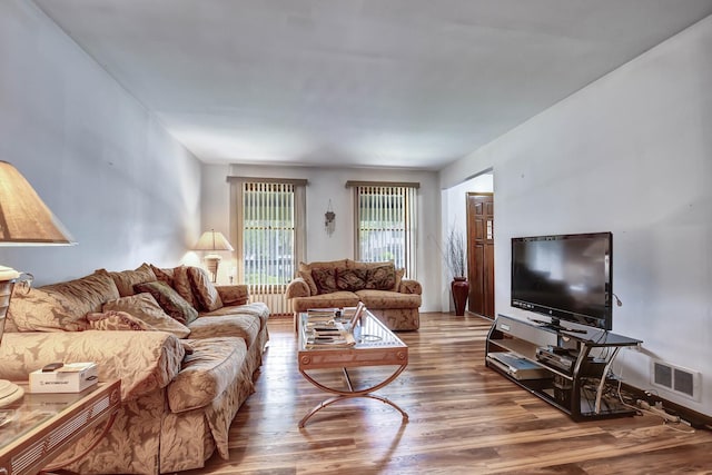 living area with visible vents and wood finished floors