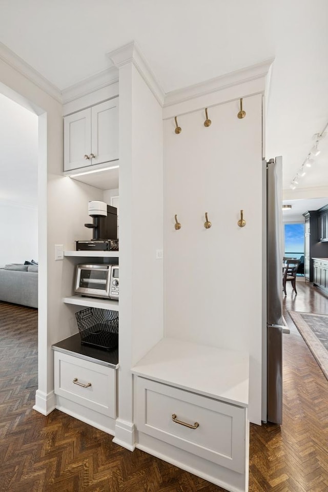 mudroom with rail lighting and crown molding