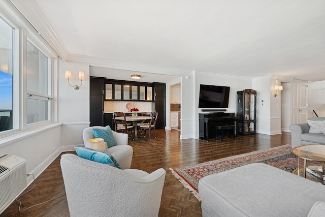 living area with a wall mounted AC, baseboards, and ornamental molding