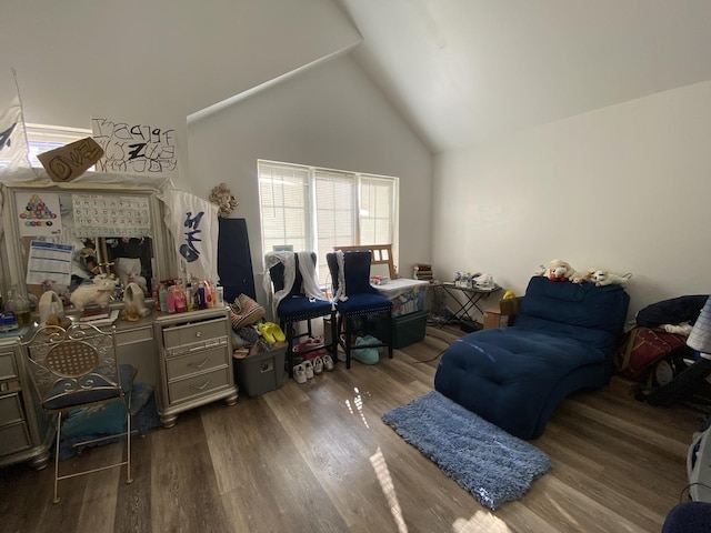 bedroom with high vaulted ceiling and wood finished floors