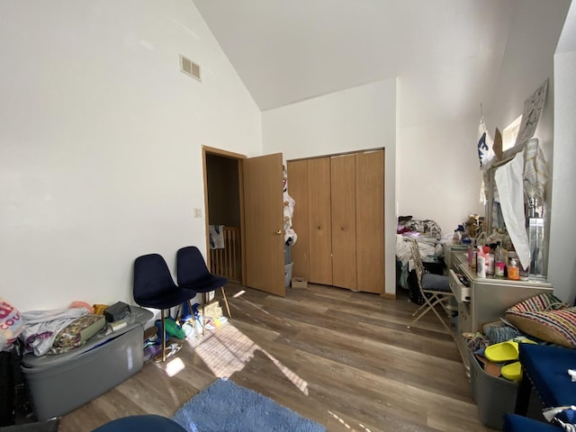 rec room featuring wood finished floors, visible vents, and high vaulted ceiling