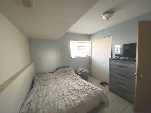 bedroom with light tile patterned floors and a closet