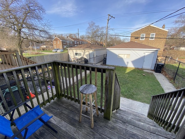 deck featuring a fenced backyard, an outbuilding, a residential view, a shed, and a lawn