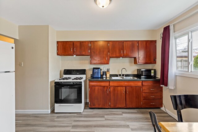 1374 Forest Pl, Calumet City, IL 60409 - kitchen featuring dark countertops, a sink, freestanding refrigerator, light wood-type flooring, and gas stove