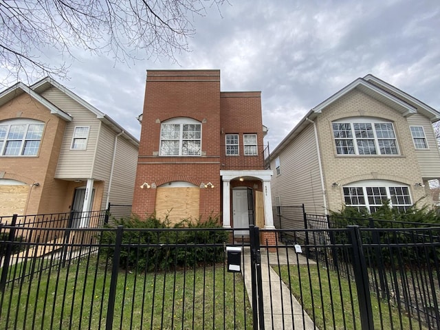 view of front of house featuring brick siding and a fenced front yard