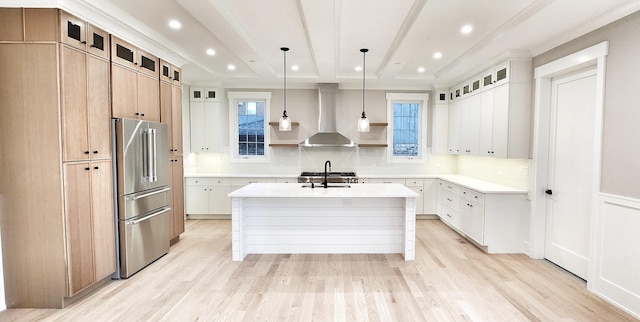 1911 S Prospect Ave, Park Ridge, IL 60068 - kitchen with wall chimney range hood, light countertops, light wood-type flooring, high end refrigerator, and a center island with sink