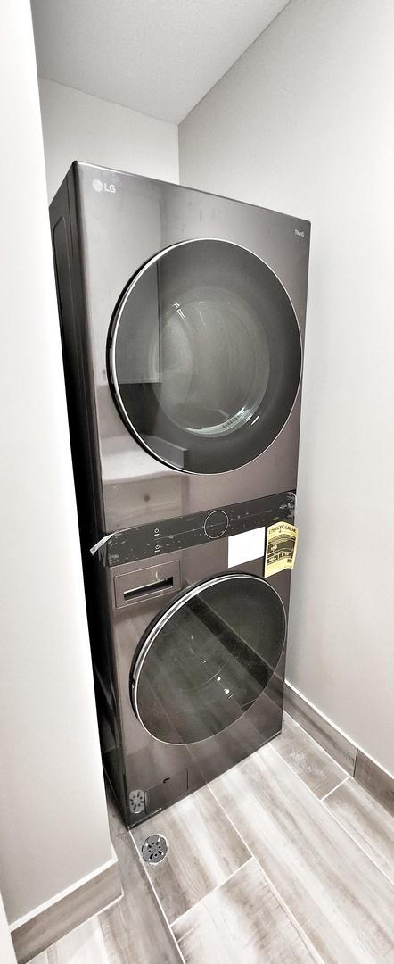 1911 S Prospect Ave, Park Ridge, IL 60068 - clothes washing area featuring wood finished floors, stacked washing maching and dryer, and laundry area