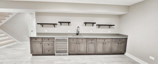 1911 S Prospect Ave, Park Ridge, IL 60068 - bar featuring beverage cooler, stairs, a sink, baseboards, and light wood-type flooring