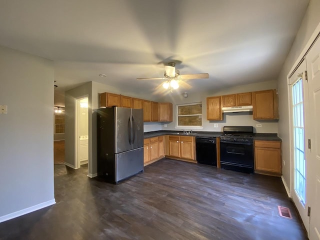 kitchen featuring visible vents, dark countertops, under cabinet range hood, black appliances, and a ceiling fan