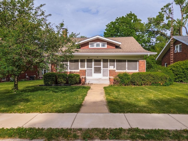 bungalow featuring brick siding and a front lawn